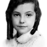 Retrato en blanco y negro de una niña con cabello oscuro y trenzas, mirada serena y expresión inocente, vestida con un abrigo claro.